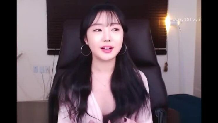 Una belleza coreana juega con sus grandes pechos.