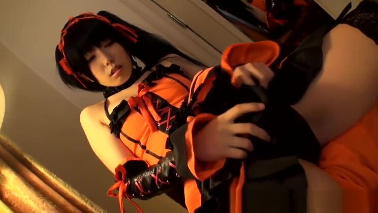 Una chica oriental disfrazada se frota el juguete en la vagina.